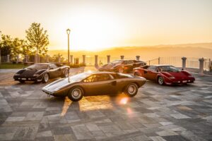 Vier verschiedene Modelle des Lamborghini Countach, aufgereiht nach ihrer zeitlichen Entwicklung, glänzend unter dem Sonnenlicht.