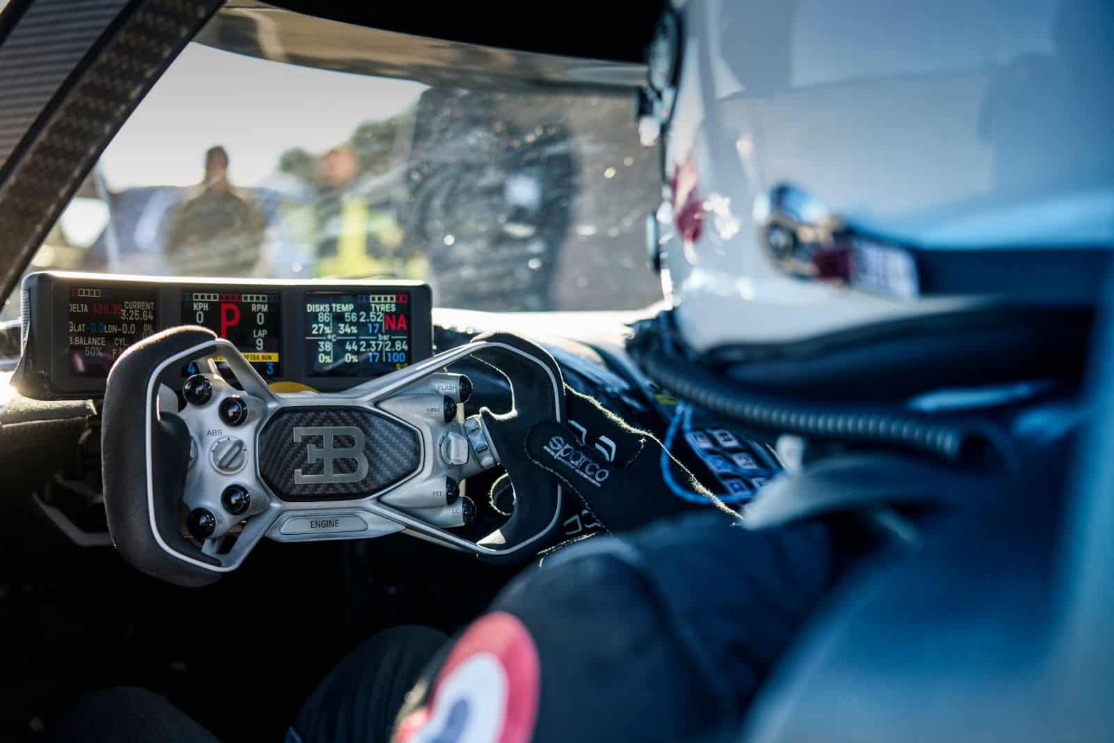 Blick auf das hochentwickelte Cockpit des Bugatti Bolide mit einem Fokus auf das Lenkrad und digitale Anzeigen, die leistungsspezifische Daten anzeigen.